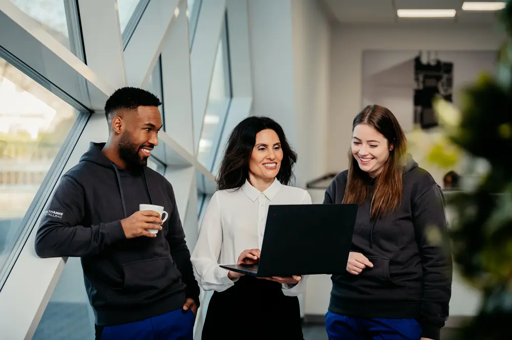 Business fotografie drei personen schauen auf einen Laptop