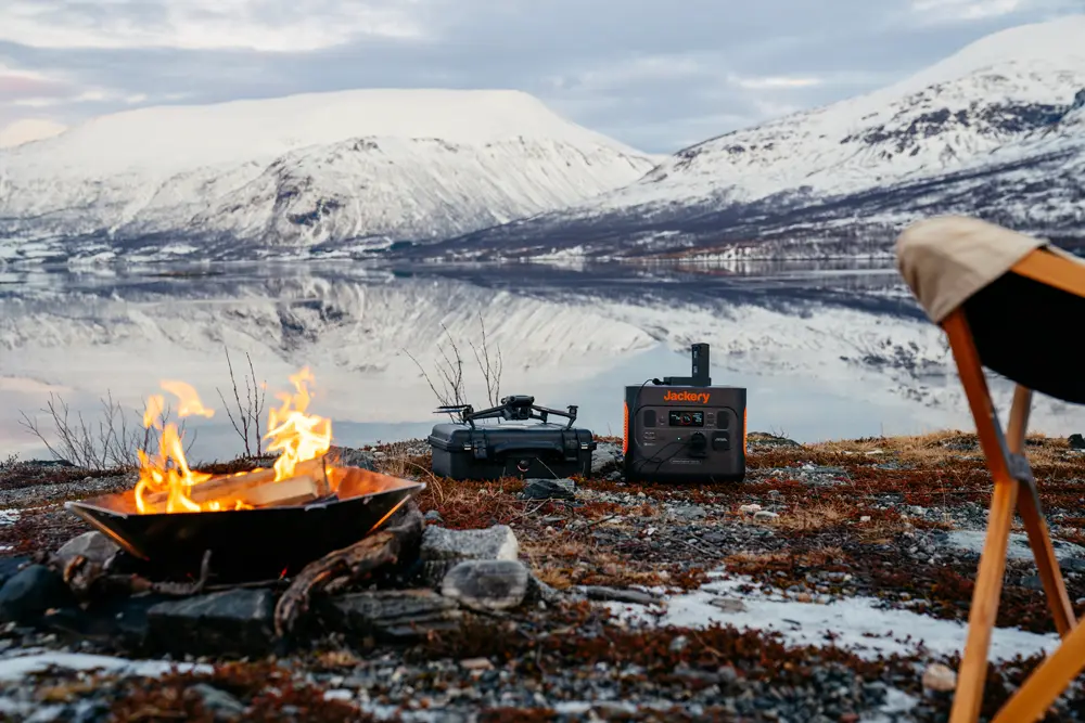 Jackry Content creaton an Lagerfeuer vor schneebedeckten Bergen